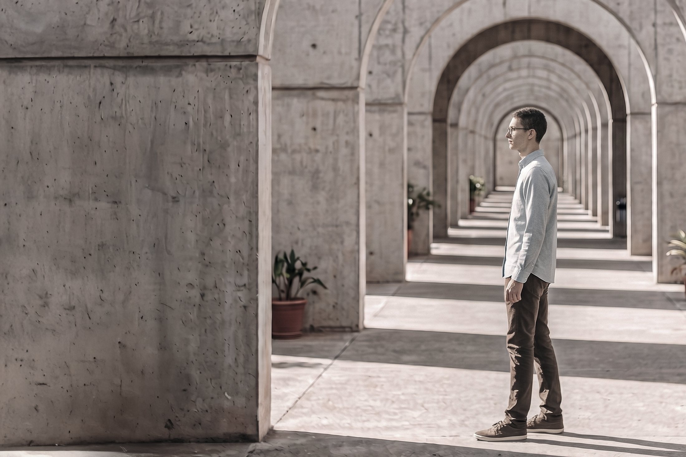 Retrato de Evandro Colombo em galeria de arcos de concreto